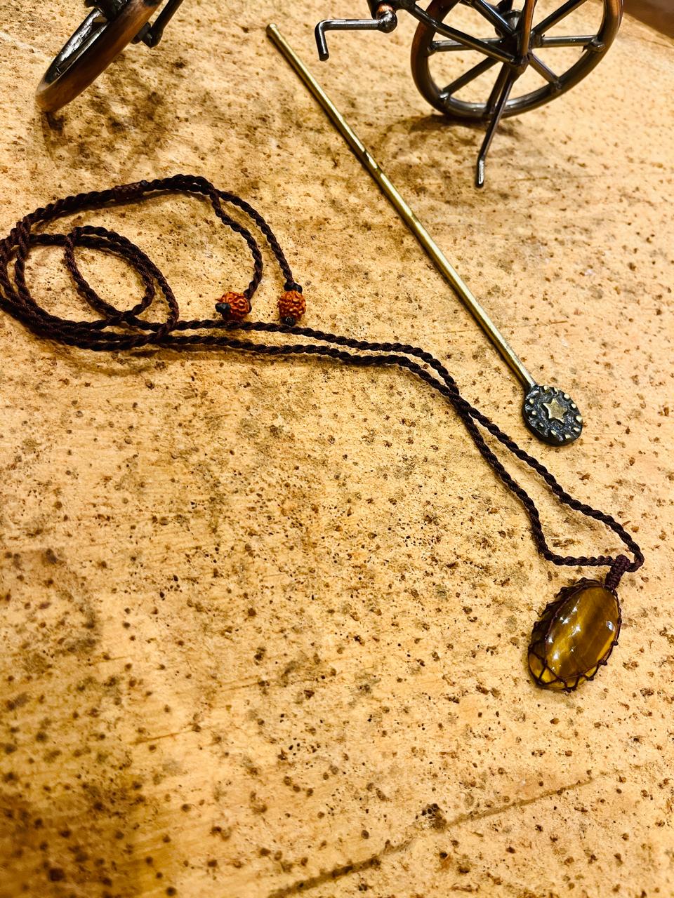 Tiger Eye pendant with natural stone in a handcrafted macrame cord, featuring earthy tones and intricate knot details.