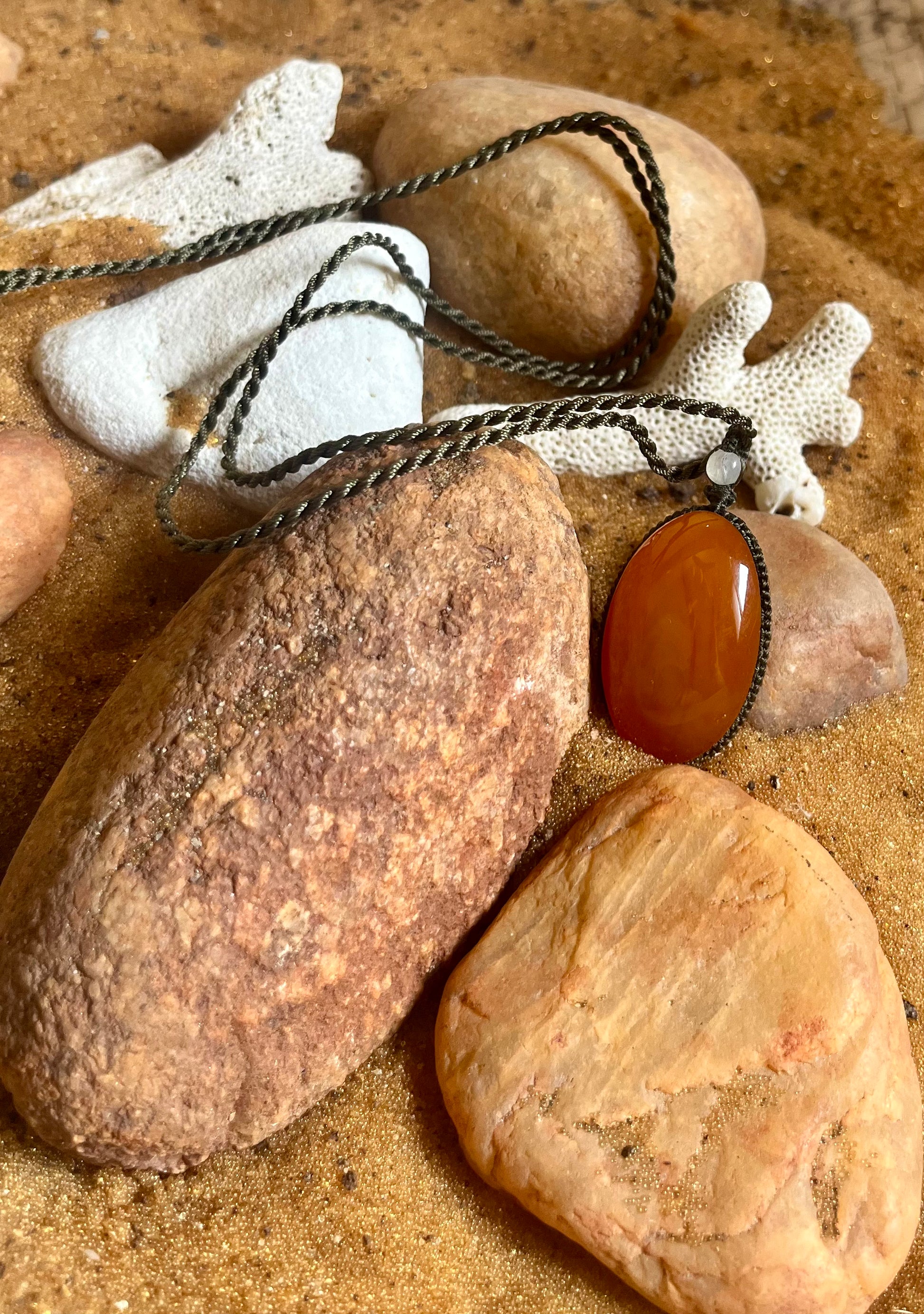 Carnelian pendant on macrame cord necklace by Season Stones, featuring a vibrant orange gemstone pendant.