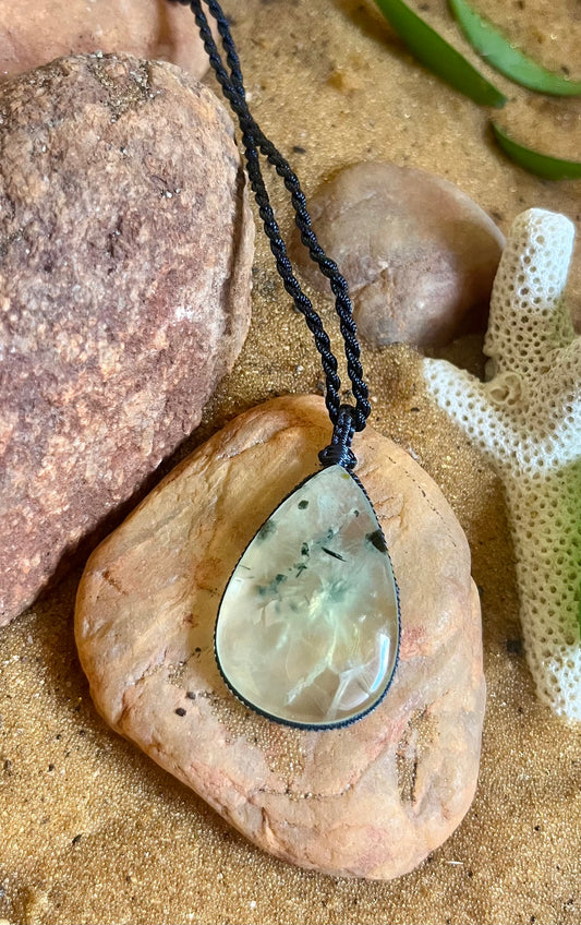 Prehnite stone in macrame cord necklace from Season Stones, featuring a polished green Prehnite pendant on woven cord.