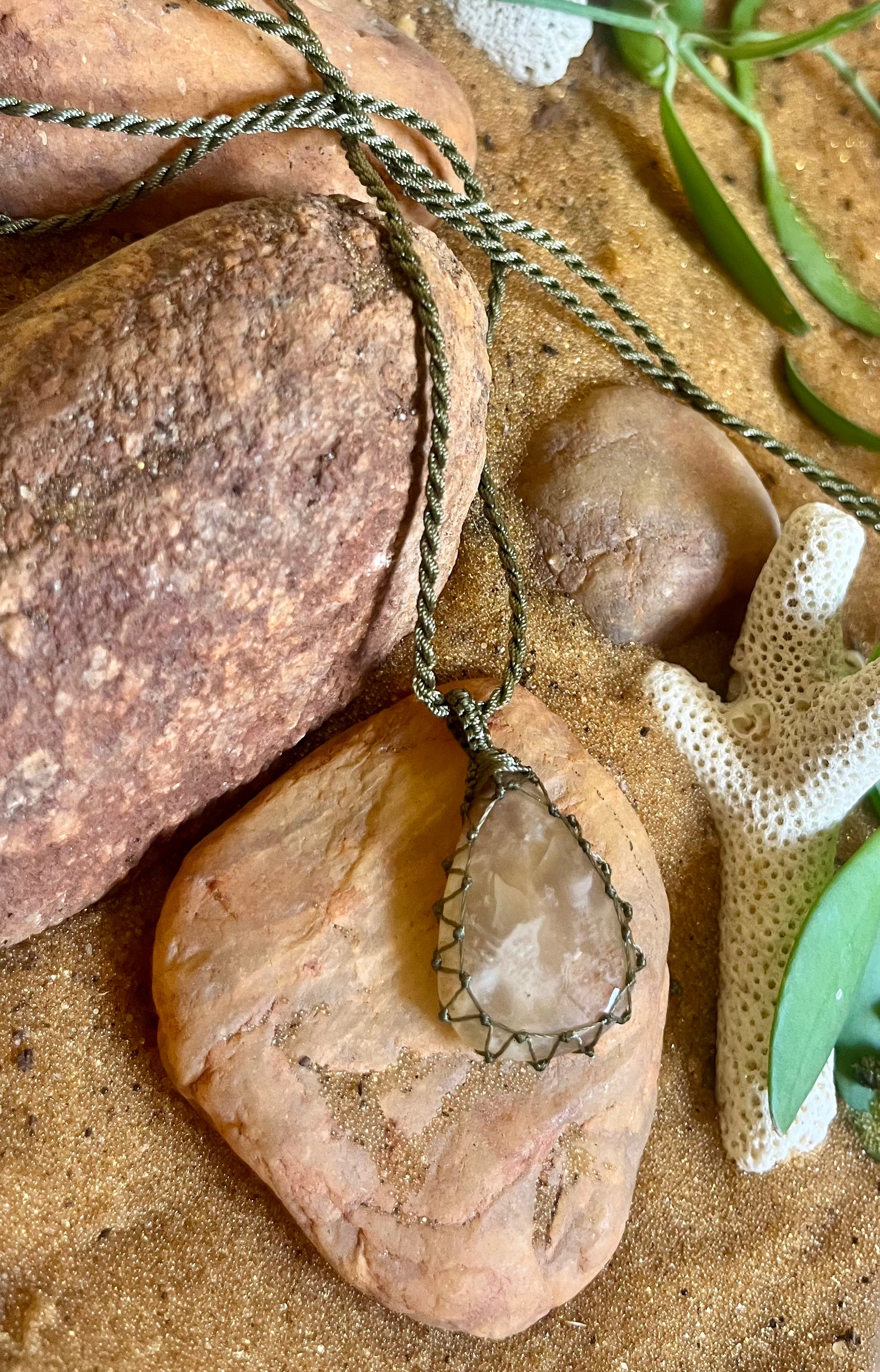 Prehnite stone pendant on macrame cord necklace by Season Stones, featuring a smooth green prehnite stone with intricate knot details.